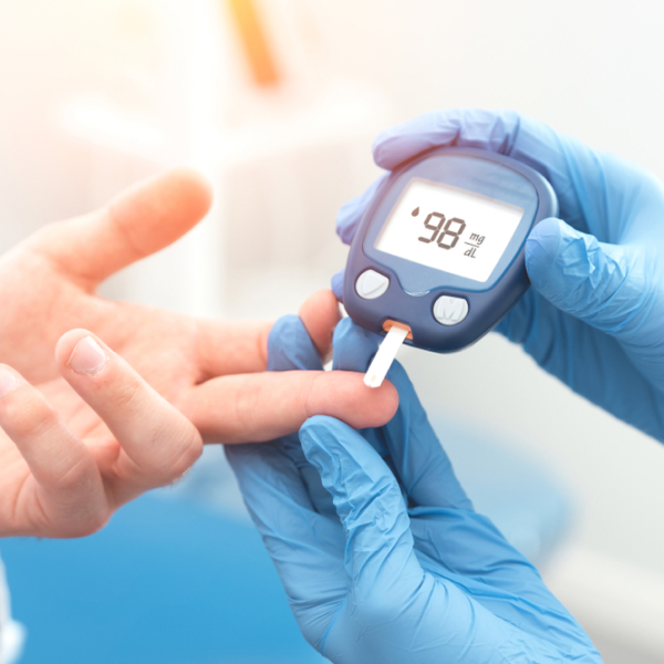 A person in blue gloves checks blood sugar on a digital device. Common causes of poor blood circulation.